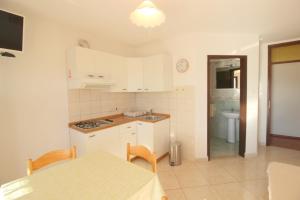uma cozinha com armários brancos, uma mesa e uma sala de jantar em MONIKA A2+1 em Novigrad Istria