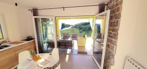 eine Küche mit einem Tisch und einer Glastür, die auf eine Terrasse führt in der Unterkunft New Apartments Škofije Ankaran in Koper