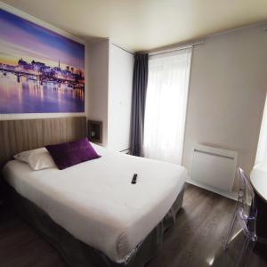 a bedroom with a large bed with a painting on the wall at Saphir Grenelle in Paris