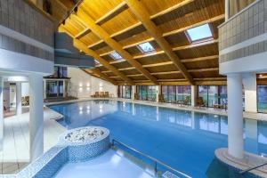 een groot binnenzwembad met een groot plafond bij Langdale Hotel & Spa in Ambleside