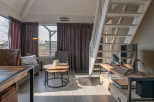 un salon avec un escalier et une table dans l'établissement Kustverhuur, Park Schoneveld, Duinroos 123, à Breskens