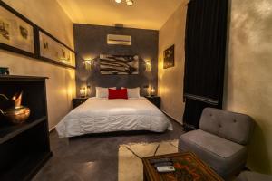 a bedroom with a bed and a chair at Riad Ksar Aylan in Ouarzazate