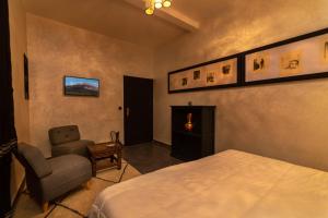 a bedroom with a bed and a chair and a window at Riad Ksar Aylan in Ouarzazate