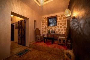 a hallway with a room with a table and a chair at Riad Ksar Aylan in Ouarzazate