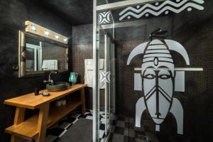 a bathroom with a shower with a painting of a face at Riad Ksar Aylan in Ouarzazate