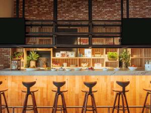 a bar with stools in front of a counter at Novotel Mexico City Toreo in Mexico City