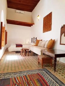 a living room with a white couch and a table at Riad Inspira in Meknès
