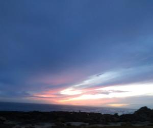a sunset over the ocean with a cloudy sky at Casarão Paraíso in Perafita