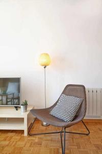 a living room with a chair and a television at SAGRADA FAMILIA VIEWS Nos preocupa su seguridad in Barcelona