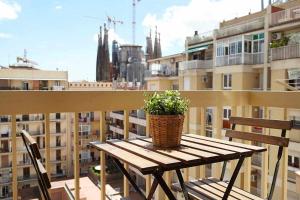 a wooden table with a potted plant on a balcony at SAGRADA FAMILIA VIEWS Nos preocupa su seguridad in Barcelona
