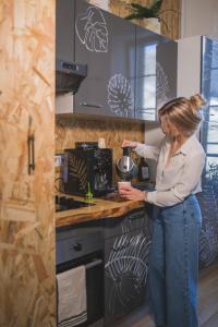 a woman standing in a kitchen preparing food at La Kanopee - Les Loges Normandes in Cherbourg en Cotentin