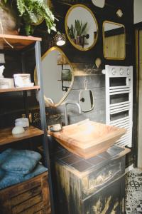 a bathroom with a sink and mirrors on the wall at La Kanopee - Les Loges Normandes in Cherbourg en Cotentin