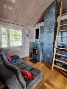 un salon avec un canapé et une cheminée dans l'établissement Vuori Camp by Saimaa, à Vuoriniemi