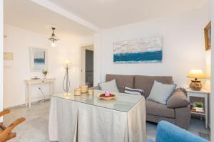 a living room with a couch and a table at Los Boliches Beach Apartment by GHR Rentals in Fuengirola