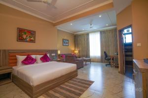 een slaapkamer met een bed en een woonkamer bij Neugal Riverfront Resort in Pālampur