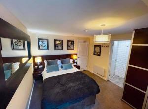 a bedroom with a large bed with blue pillows at The High Flyer in Ely