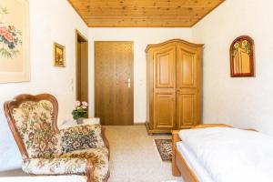 a bedroom with a bed and a chair and a door at Am Wehrastrand Einzelappartment in Todtmoos