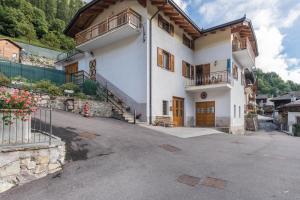 a large white house with a balcony and a driveway at Casa al sole in Bresimo
