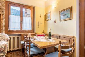 a dining room with a table and a bottle of wine at Casa al sole in Bresimo +25 photos