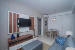 ein Wohnzimmer mit einem Sofa und einem Flachbild-TV in der Unterkunft Residencial Anchieta Riviera By Audaar in Riviera de São Lourenço
