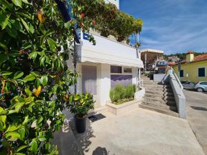 a white building with stairs and plants at Apartment Rabac 2127 in Rabac +8 photos