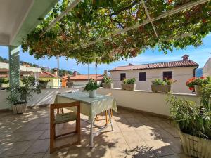 a table and chair on a balcony with plants at Apartment Rabac 2127 in Rabac