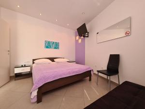 a bedroom with a purple bed and a chair at Apartment Rabac 2127 in Rabac