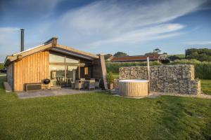 a house with a stone wall and a patio at Bramble in Ansty