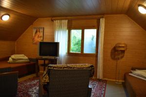 a living room with a television and a window at Lauku sēta Svētupes in Salacgrīva