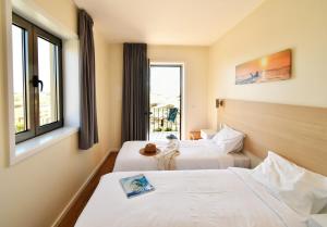 a hotel room with two beds and a window at Surfivor Surf Camp in Esmoriz