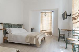 a bedroom with a bed and a table and a window at Agriturismo Belvedere 9 in La Spezia