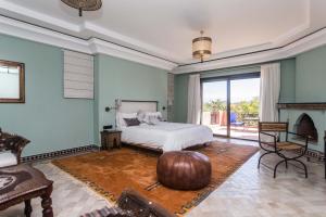 a bedroom with a large bed and a fireplace at La Villa Rose Anna in Marrakesh +10 photos