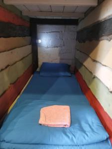 シェレゲシュにあるBear Holeのタオル付きの小さな部屋のベッド1台分です。