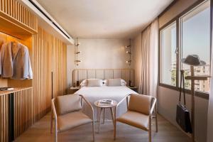 a bedroom with a bed and two chairs and a table at Only YOU Hotel Málaga in Málaga