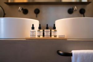 a shelf with three bottles of moisturizers on it at Only YOU Hotel Málaga in Málaga