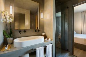 a bathroom with a white sink and a bed at Only YOU Hotel Málaga in Málaga
