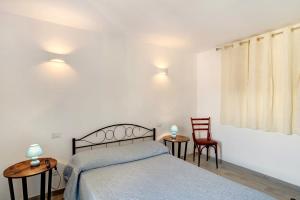 a bedroom with a bed and two chairs at G House Dolceacqua in Dolceacqua