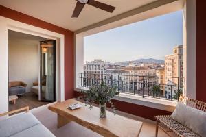 a living room with a table and a large window at Only YOU Hotel Málaga in Málaga