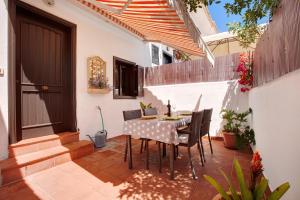 eine Terrasse mit einem Tisch, Stühlen und einer Tür in der Unterkunft Casa Dos Ángeles in Arona