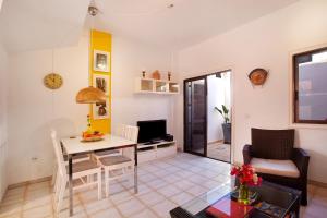 ein Wohnzimmer mit einem Tisch und einem Schreibtisch in der Unterkunft Casa Dos Ángeles in Arona