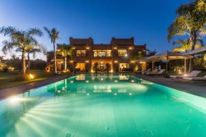 a large swimming pool in front of a house at La Villa Rose Anna in Marrakesh