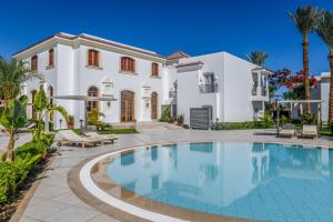 a large white house with a swimming pool in front of it at Jaz Fanara Residence in Sharm El Sheikh