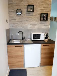 a small kitchen with a sink and a microwave at Superbe studio 15 m²,proche Disney, Asterix, CDG in Gressy