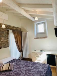 Schlafzimmer mit einem Bett, einem Schreibtisch und einem Fenster in der Unterkunft Oreste Suite in Lazise