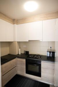 cocina con armarios blancos y fogones en Apartman Martes en Slavonski Brod