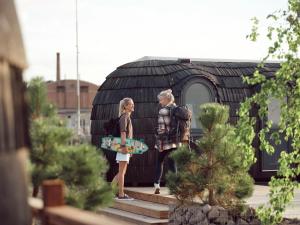 two girls are standing outside a house with a skateboard at Iglupark in Tallinn
