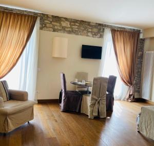 a living room with a table and chairs and windows at Oreste Suite in Lazise