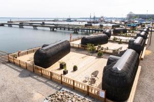 a group of large tires sitting on a dock next to the water at Iglupark in Tallinn