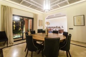 a dining room with a wooden table and chairs at La Villa Rose Anna in Marrakesh