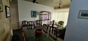 une salle à manger avec une table et des chaises en verre dans l'établissement Ap da Mama, à Guarujá